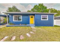 Charming home with blue siding and a vibrant yellow front door, complemented by a well-maintained lawn at 201 83Rd N Ave, St Petersburg, FL 33702