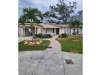 Charming single-story home with carport, landscaped yard, and brick walkway at 201 S Treasure E Dr, Tampa, FL 33609