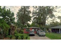 Charming single-story home featuring a classic red brick facade and a well-maintained front yard with mature trees at 2110 Oakley S Ave, St Petersburg, FL 33712