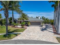 Beautiful single-story home featuring a paver driveway, lush landscaping, and an attached two-car garage at 6614 Blackfin Way, Apollo Beach, FL 33572