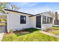 Charming home featuring a well-maintained lawn and a cozy entryway with a black door at 711 19Th S Ave, St Petersburg, FL 33705