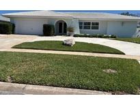 Well-manicured lawn and landscaping enhance the curb appeal of this single story home at 731 Snug Is, Clearwater, FL 33767