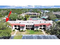 Attractive condo building with red tile roof, manicured landscaping, and ample parking at 9700 Starkey Rd # 321, Seminole, FL 33777