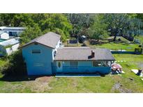Aerial view of a two-story home with a large backyard and mature trees providing plenty of shade at 10034 Burton St, New Port Richey, FL 34654