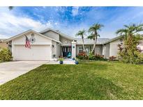 Charming single-story home featuring a well-manicured lawn and tropical landscaping at 1031 Ridge View Ln, Palm Harbor, FL 34683