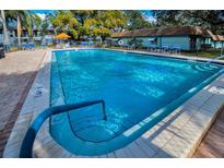 Sparkling community pool surrounded by lounge chairs and lush landscaping offers a refreshing escape at 200 Glennes Ln # 201, Dunedin, FL 34698