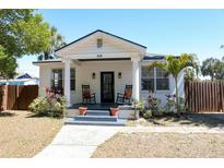 Charming single-story home featuring a welcoming porch with rocking chairs and well-maintained landscaping at 205 N Westland Ave, Tampa, FL 33606