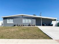 A cozy single-story home featuring a gray exterior, white trim, and a well-manicured lawn at 21298 Austin Ave, Port Charlotte, FL 33952
