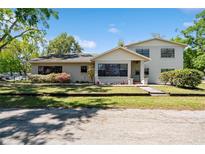 Inviting two-story home featuring manicured lawn, flower beds and a welcoming front porch at 2207 W Ohio Ave, Tampa, FL 33607