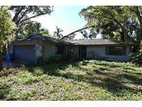 Modest single Gathering home exterior with overgrown front yard and attached garage at 511 Moore Ave, Seffner, FL 33584