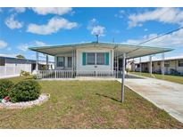 Charming mobile home with a well-maintained lawn and covered carport in a peaceful community at 5306 Mary St, Zephyrhills, FL 33542