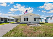 Charming single-story home featuring a carport, manicured lawn, and decorative stonework at 5745 Pawnee St, Zephyrhills, FL 33542