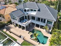 Stunning aerial view of a modern two-story home with a private pool and waterfront access at 6113 Pasadena Point Blvd, Gulfport, FL 33707