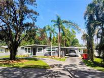 Charming single-story home with well-manicured lawn, mature trees, and a convenient carport at 11233 51St N Ave, St Petersburg, FL 33708