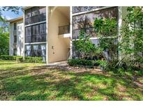 Exterior view of a two-story property with an exterior staircase and walkway at 1398 Shady Pine Way # H2, Tarpon Springs, FL 34688