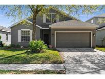 Charming single-Gathering home with a gray exterior, well-maintained lawn, and a two-car garage at 200 Fairmont Dr, Spring Hill, FL 34609