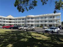 Beautiful condo building with white balconies and manicured lawn under a clear blue sky at 2428 Columbia Dr # 72, Clearwater, FL 33763