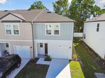 Charming two-story townhome features a one-car garage and freshly landscaped front yard at 4326 Banjo Lake Rd, Land O Lakes, FL 34639