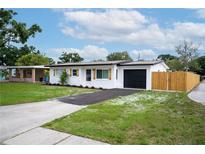 Charming single-story home with a well-manicured lawn, blacktop driveway, and a freshly painted white exterior at 4601 71St N Ave, Pinellas Park, FL 33781