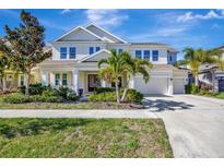Beautiful two-story home with a well-manicured lawn, lush landscaping, and a three car garage at 6324 Brevada Ln, Apollo Beach, FL 33572