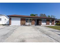Charming single-story brick home with attached garage and spacious concrete driveway at 724 Tradewinds Dr, Brandon, FL 33511