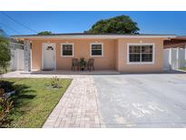 Charming single-story home featuring a cozy front porch and well-maintained lawn and brick walkway at 8210 Marigold Ave, Tampa, FL 33614