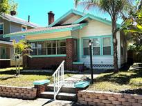 Charming two-story home featuring brick accents, a well-manicured lawn, and welcoming front steps at 160 16Th Ne Ave, St Petersburg, FL 33704