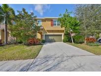 Charming two-story home featuring a well-maintained lawn and a spacious two-car garage at 6338 Springline Pl, Apollo Beach, FL 33572