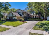 Charming two-story Tudor-style home with lush lawn and mature trees at 1439 Wetherington Way, Palm Harbor, FL 34683