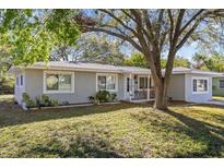 Inviting single-story home with a lush front yard and mature trees, enhancing curb appeal at 1653 S Prescott Ave, Clearwater, FL 33756