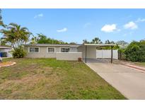 Charming single-story home featuring a carport, landscaped yard, and a well-maintained exterior at 5103 Town N Country Blvd, Tampa, FL 33615