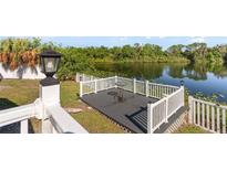 Lake view from a backyard deck with white railings, with table and chairs at 8024 Timberlane Dr, Tampa, FL 33615