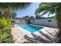 Private pool surrounded by lush landscaping and brick pavers creating a serene backyard oasis at 1101 39Th Ne Ave, St Petersburg, FL 33703