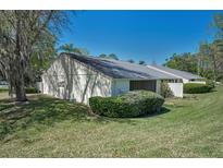 Quaint single-story home featuring a well-manicured lawn and a screened-in porch for enjoying the outdoors at 1333 Shady Pine Way # F, Tarpon Springs, FL 34688