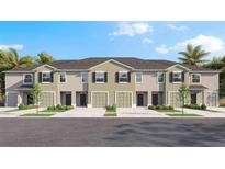 New townhouse exterior showcases garages, black door, dark shutters, light landscaping, and a modern design at 228 Royal Spoonbill Dr, Ruskin, FL 33570