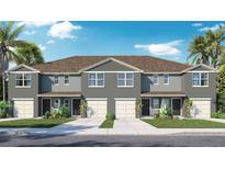 New two-story townhome with gray exterior, individual garages, manicured lawn and tropical palm trees on a sunny day at 31254 Midnight Sun Way, Wesley Chapel, FL 33545