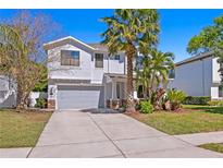 Charming two-story home with a well-manicured lawn, a two-car garage, and beautiful palm trees at 3615 W Kensington Ave, Tampa, FL 33629