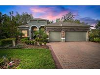 Beautiful one-story home with a three-car garage, stone accents, and lush landscaping at 3633 Cordgrass Dr, Valrico, FL 33596