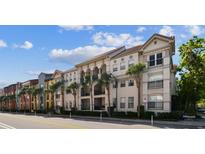 Attractive condominium building featuring neutral stucco, Mediterranean style roof, and decorative pillars and trees at 402 S Armenia Ave # 137, Tampa, FL 33609