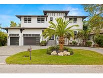 Beautiful two-story modern home featuring a well-manicured lawn, a palm tree, and a two-car garage at 4806 W San Rafael St, Tampa, FL 33629