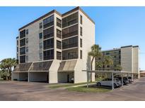 Exterior of condo building with a covered parking area and palm trees in a well-maintained community at 9860 62Nd N Ter # 1051, St Petersburg, FL 33708