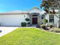 Charming single-story home with a well-manicured lawn, mature trees and a double door entrance at 14305 Tennyson Dr, Hudson, FL 34667