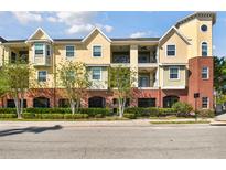 Beautiful yellow and brick condo building featuring front-facing balconies and manicured landscaping at 2010 E Palm Ave # 15210, Tampa, FL 33605