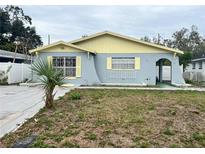 Charming single-story home featuring a light blue exterior with yellow accents and a cozy front yard at 2944 W Beach, Tampa, FL 33607