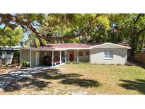 Charming single-story home with a covered carport and well-maintained lawn and mature trees at 7303 N Branch Ave, Tampa, FL 33604