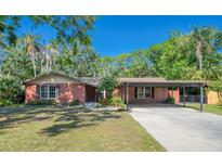 Charming brick home featuring a covered carport and lush landscaping at 8136 Honeybee Ln, Tampa, FL 33635