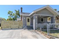 Charming home with a gray exterior, a yellow door, and a newly constructed wooden fence at 1010 8Th S Ave, St Petersburg, FL 33705