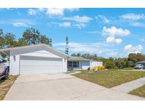 Charming one-story home showcasing a two-car garage and inviting curb appeal under a blue sky at 13415 Andova Dr, Largo, FL 33774