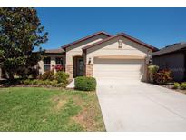 Charming single-story home with a well-manicured lawn and a two-car garage at 16331 Treasure Point Dr, Wimauma, FL 33598