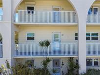 Three story building featuring neutral colors, white railings, archways, and lush landscaping at 2259 Costa Rican Dr # 23, Clearwater, FL 33763
